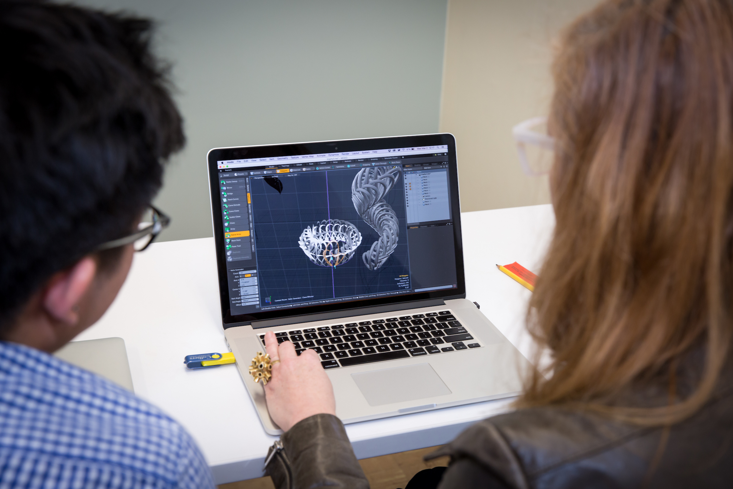 over the shoulder view of people looking at 3d print design on screen