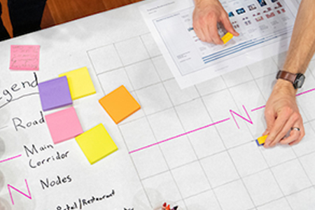 hand works over a grid that looks like an economics model
