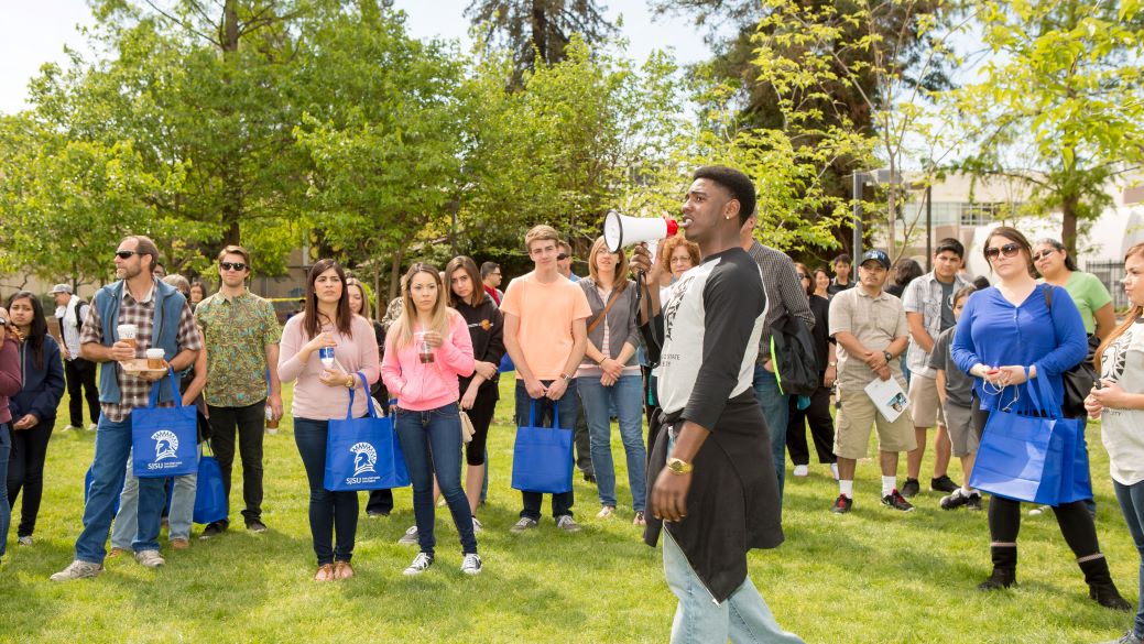 Student speaks to visitors on tour near Tower Lawn